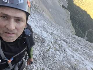 Mann macht Selfie in ausgesetzter Bergwand