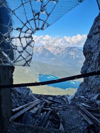 Blick durch zerbrochenes Fenster auf türkisblauen See
