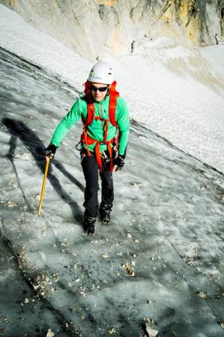 Mensch läuft mit Gletscherausrüstung Gletscher hoch