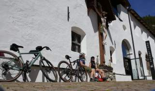 Zwei junge Frauen sitzen mit ihren Gravelbikes vor dem  Kloster Marienberg