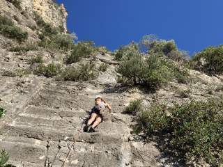 Kletterin an teils bewachsener Wand