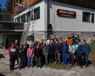Gruppe von Personen vor einer Hütte