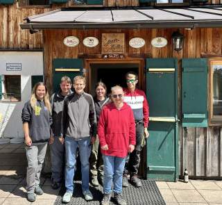 Personen vor einer Hütte