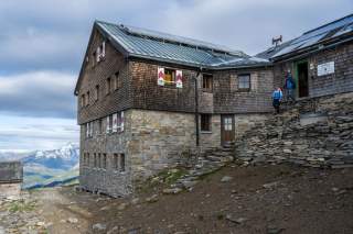 Zwei Menschen kommen aus Berghütte