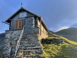 Eine Berghütte im warmen Sonnenaufgangslicht.