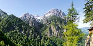 Blick auf Berggipfel. Talnah frisch-grüne Bäume, weiter oben liegt noch Schnee.