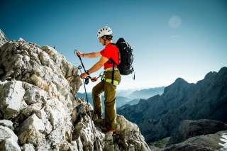 Man hängt sich am Klettersteig ein Man hängt sich am Klettersteig ein
