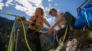 Angelika und Salomé überprüfen sämtliche Schäkel und Verbindungen, bevor die erste Person die Highline betritt.