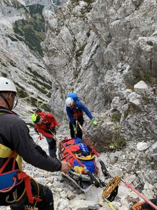 Personen der Bergwacht transportieren Opfer per Trage und Seilwinde nach unten