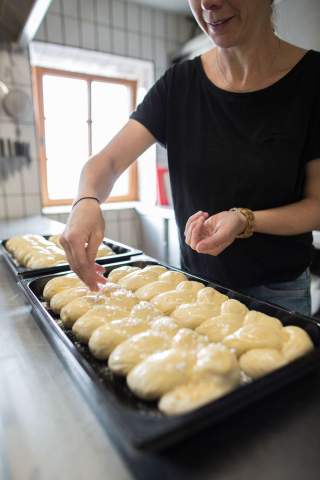 Frau beim Backen von Hefezöpfen