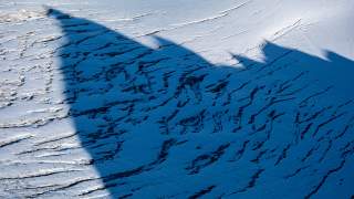 Schatten eines Gipfels auf dem zerrissenen Glacier du Mont Minet.
