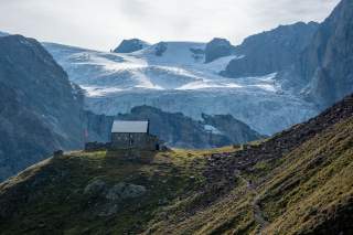 Die urige Schönbielhütte posiert vor großer Bergkulisse mit Gletschern.