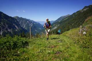 Wanderinnen laufen Wiese hinauf