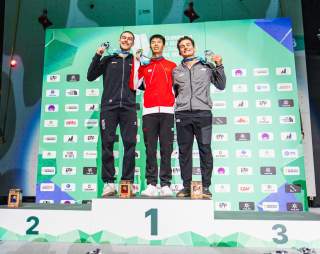 Drei Kletterer auf dem Podium