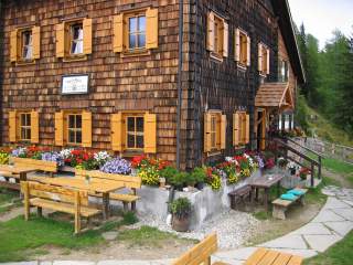Hütte mit Schindeln und viel Blumendekoration