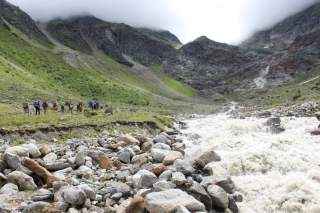 Gruppe von Wandernden an reißendem Gebirgsbach
