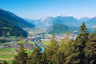Panoramablick auf den Inn in Tirol, viele Ortschaften an den Ufern, im Hintergrund Berge.