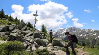 Frau und Junge auf einem Bergpfad. Sie steigen bergauf.