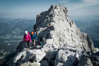 Mehrere Personen laufen Berggrat entlang