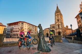 Drei Biker auf einem Platz vor einer mächtigen Kathedrale.