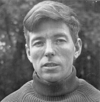 Schwarz-weiß-Porträt eines Mannes mit kurzem Haar und Rollkragenpullover, der direkt in die Kamera blickt.