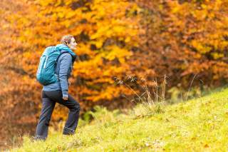 Frau wandert durch herbstliche Landschaft