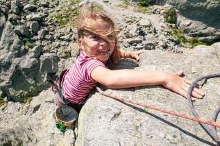 Kind klettert am Felsen