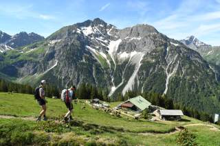 Zwei Menschen wandern zu Alpe hinab