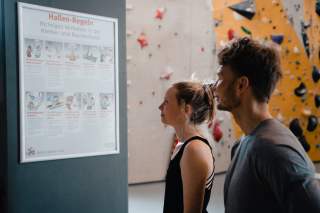 Kletterer stehen vor Hallen-Regeln