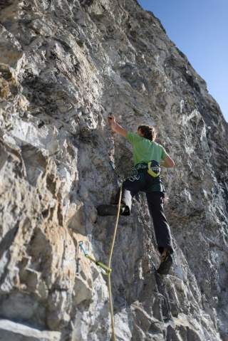 Mann klettert Felswand hoch