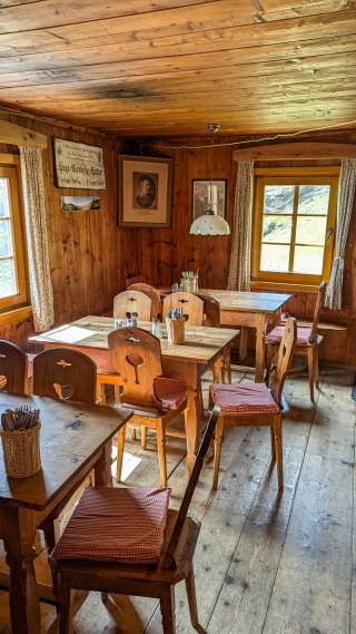Der holzvertäfelte Gastraum einer Berghütte.