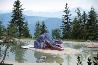 Plastik Dinosaurier in künstlich angelegtem Teich im Triassic Park auf der Steinplatte.