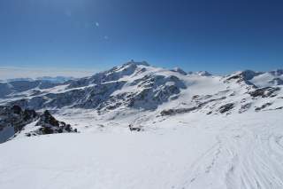 Vergletscherte Hochgebirgslandschaft im Sonnenschein mit dünner Schneeauflage