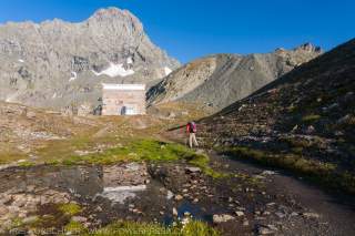 Mensch wandert auf Berghütte zu
