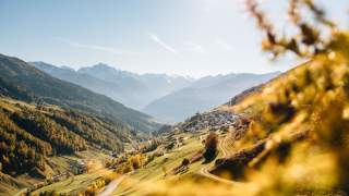 Blick vom Berg auf das Dorf Matsch, das sich am Talhang befindet.