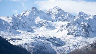 Schneeweiß liegen die zackigen Gipfel der Silvretta vor dem blauen Himmel.