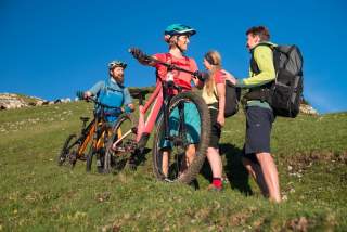 Menschen mit Mountainbikes machen auf Bergpfad Platz für Wandernde