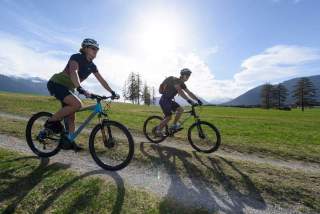 Zwei Menschen auf Mountainbikes auf Bergwiese