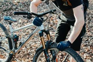 Mensch prüft Luftdruck von Mountainbike-Reifen