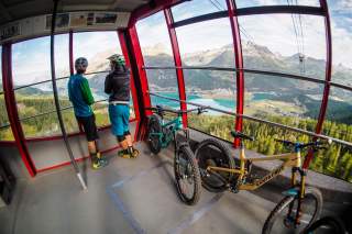Paar mit Mountainbikes in der Seilbahn