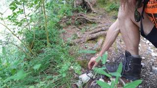 Mann hebt Stück Plastik von Wanderweg auf