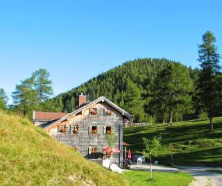 Hütte in lieblichem Almgelände im Sonnenschein