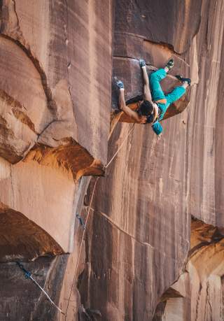 Ninca Caprez klettert kopfüber im Indian Creek (Utah) herum.