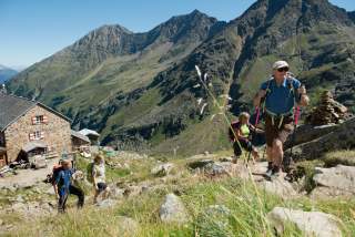 Vier Menschen wandern weg von Hütte