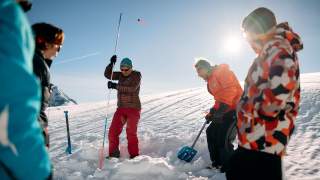 Gruppe übt LVS-Suche mit Sonde im Schnee