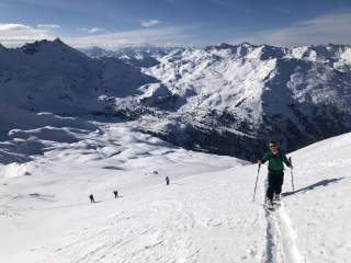 Menschen gehen mit Splitboards verschneiten Berg rauf