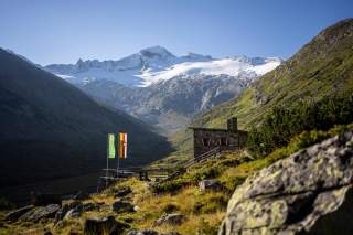 Blick auf die Osnabrücker Hütte mit Gletscher im Hintergrund.