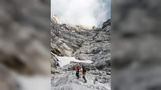 Zwei Menschen wandern in felsigem Gelände