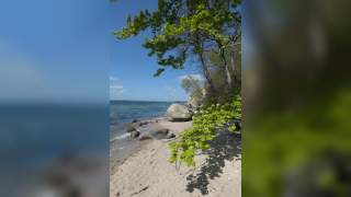 Blick auf einen Strand mit großen Steinen am Ufer.