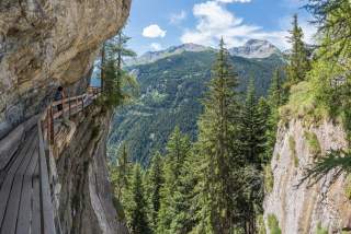 Frau wandert am Berg entlang eines ehemaligen Bewässerungskanals